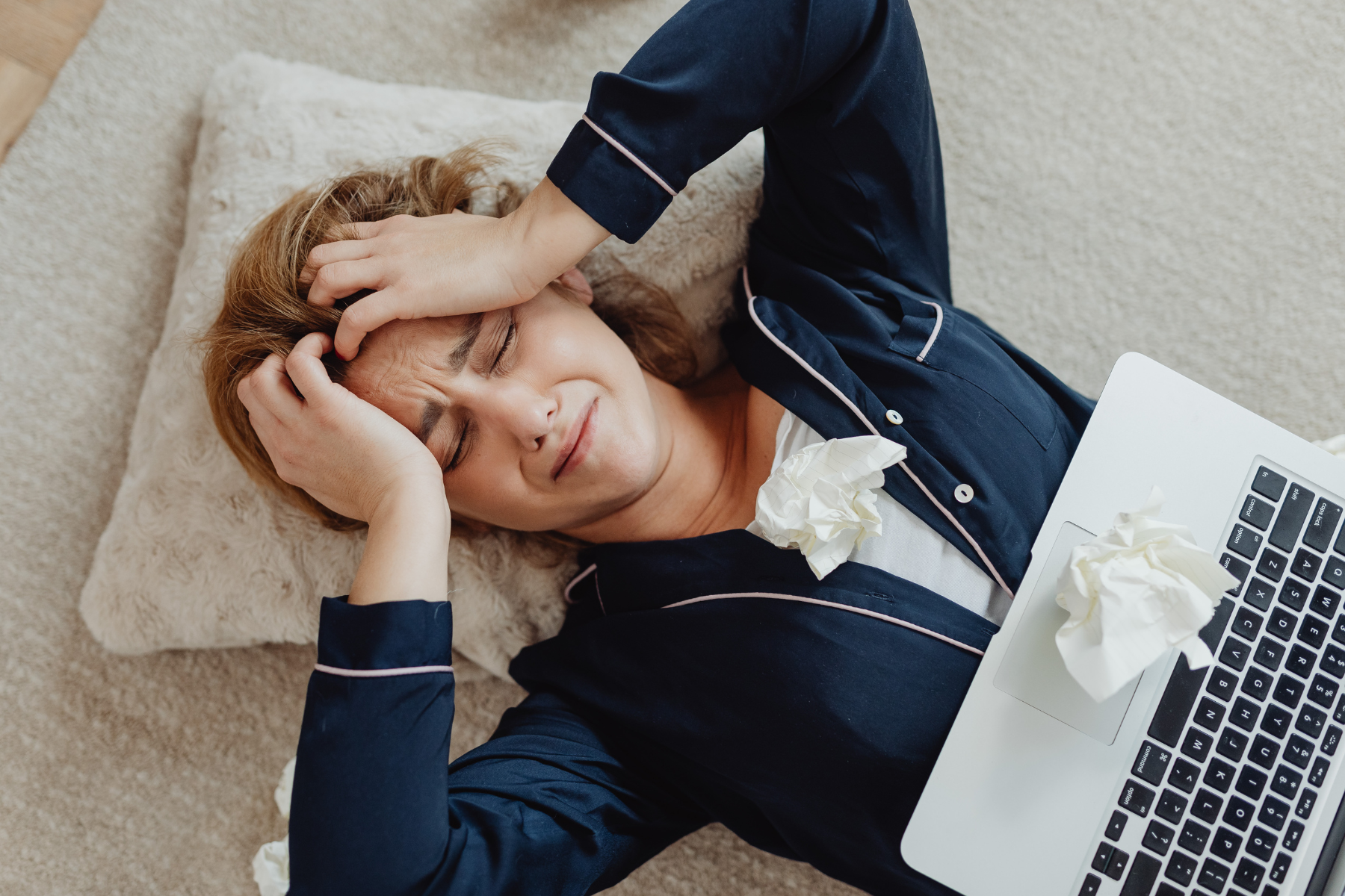 Overwhelmed by the Probate Process Stressed woman lying on the floor with a laptop and crumpled tissues, overwhelmed by paperwork or legal issues